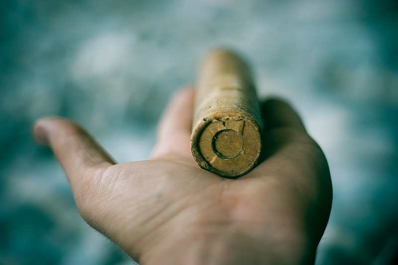 A closed cardboard tube sitting on a flat palm.