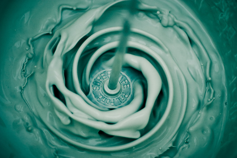 A rapidly-spinning mixer swirls an opaque liquid.