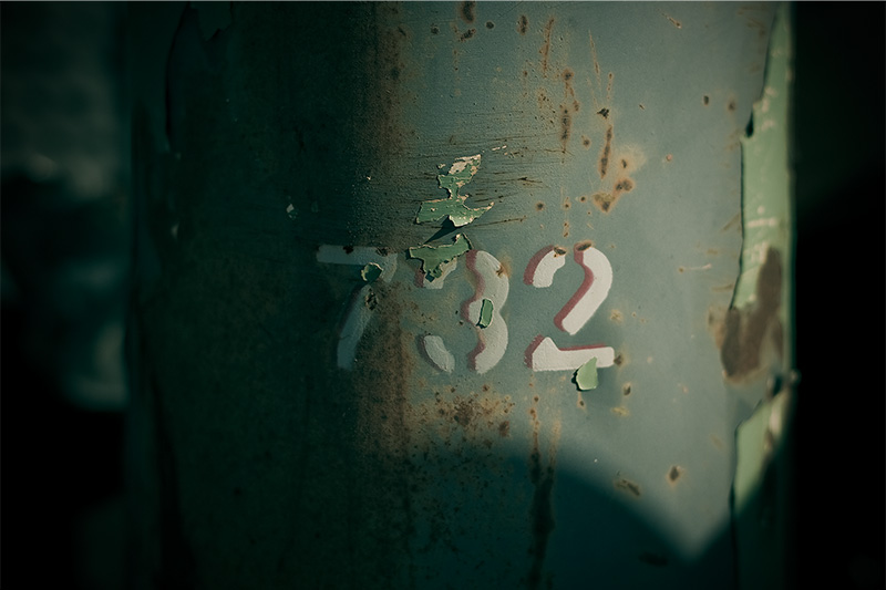 The numbers '702' painted in white onto a green cylinder.