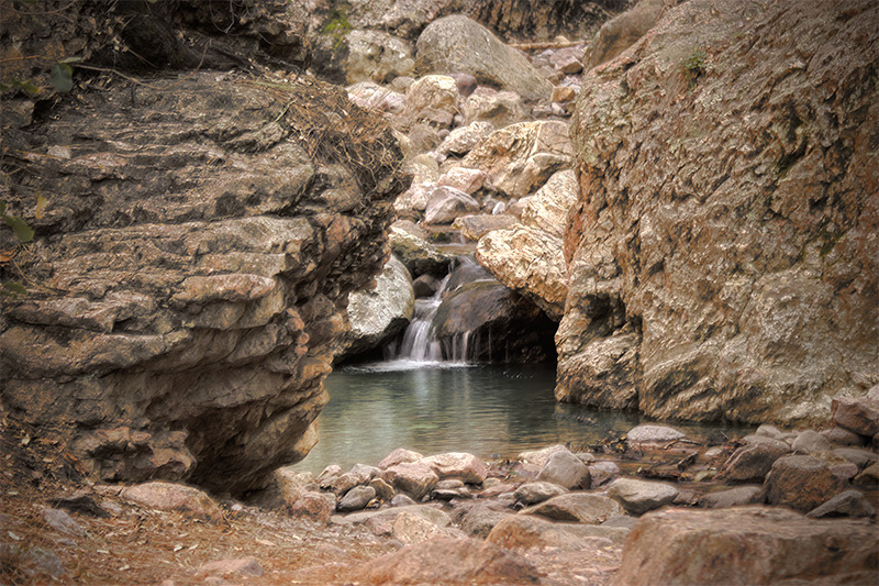 A small waterfall, surrounded by rocks.