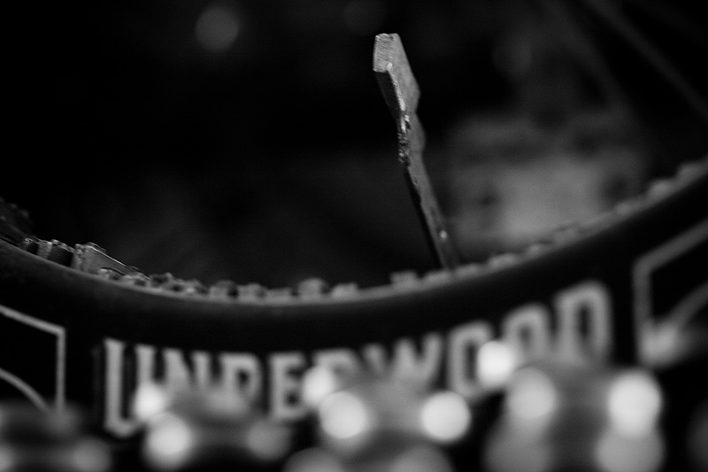 A detailed view of an Underwood typewriter with a single hammer raised.