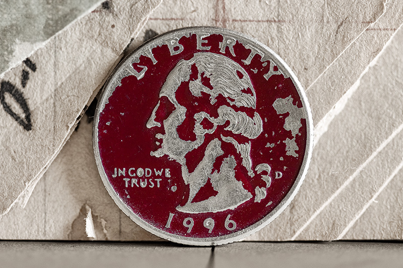 A red quarter in front of old, dogeared paper.