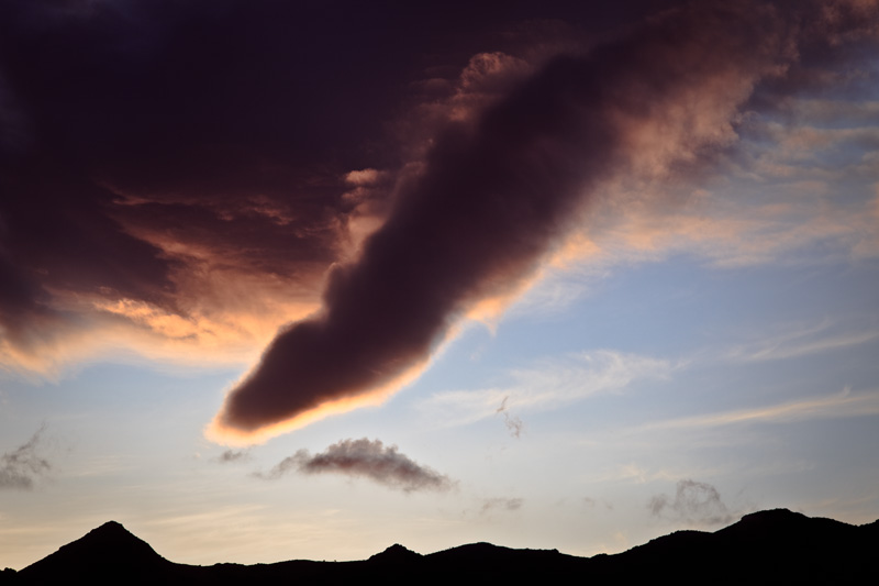 A cloud resembling a tornado descending from the sky.