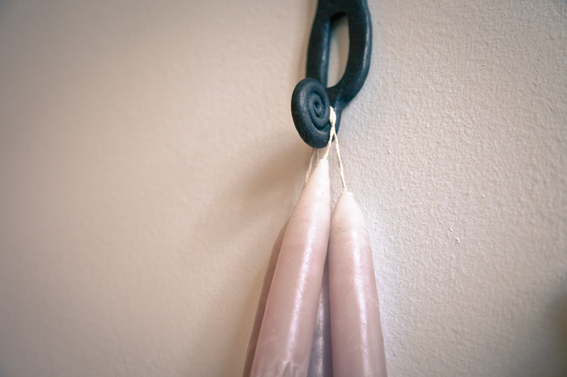 Some candles hanging from a hook.