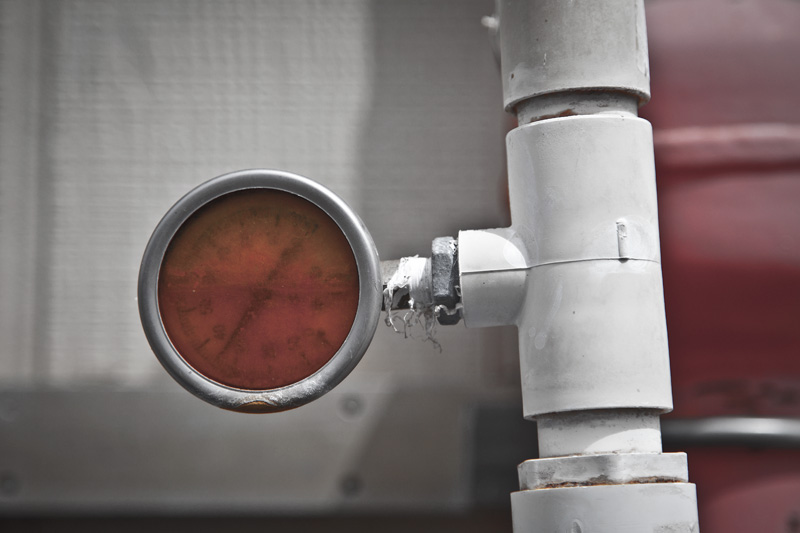 A water pressure gauge stained a frightening orange color.
