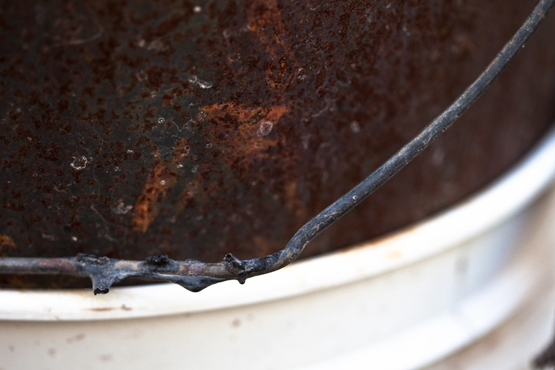 Rusty metal within a bucket.
