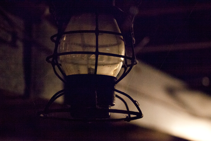 A lantern, barely illuminated itself.