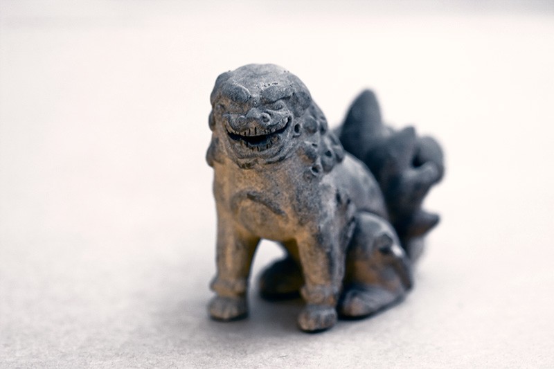 A Chinese guardian lion figurine grinning maniacally.
