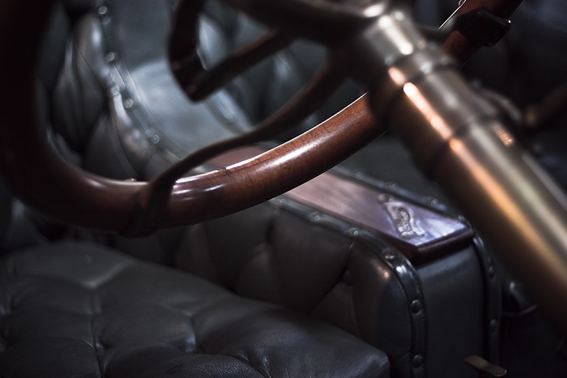 A copper & brass steering wheel in an antique car.