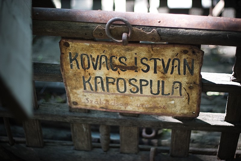 An old sign attached to the side of an antique wagon.