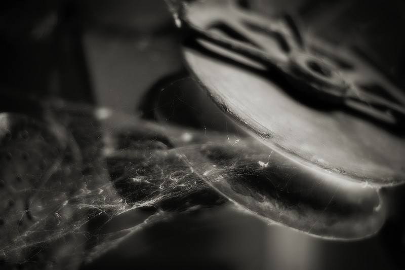 An antique pulley covered in cobwebs.