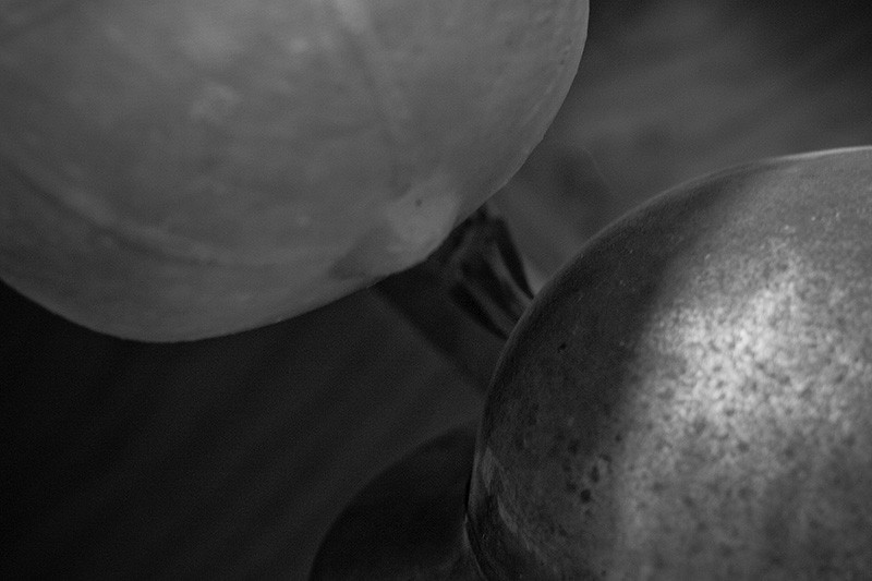 A fabric pith helmet hanging beside a steel construction helmet.