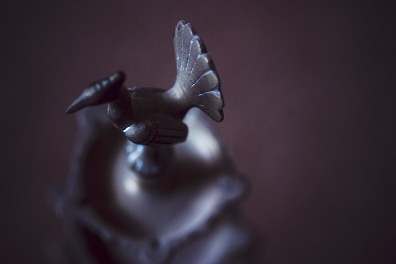 Metal peacock at the top of a multi-layered tray.