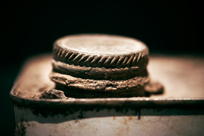 The screw-on cap of an old, rusty metal can.