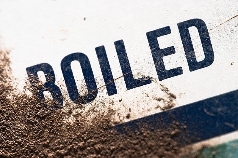 The word "boiled" slanting diagonally out of a surface-covering of dirt.