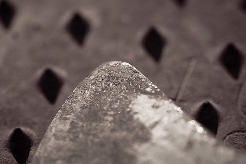 Two rusty metal objects, resembling an overlook above a field of pyramids.
