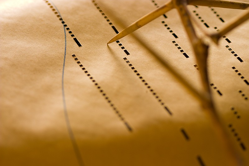 Mesquite thorns over a player piano roll.