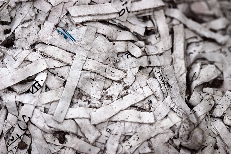 Shredded paper matted together, two pieces forming a cross.