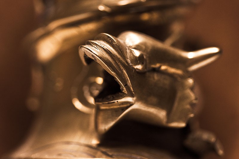 A brass dragon with its mouth open.