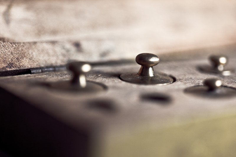 Brass diamond weights sitting in their case.