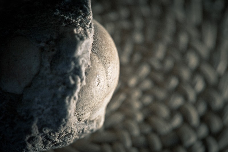 A geode partially enclosed in surrounding, rougher rock.