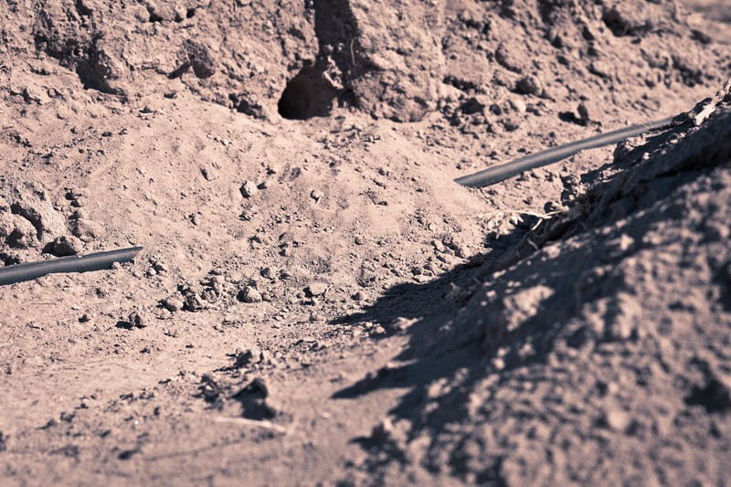 A black pipeline passing through a canyon.