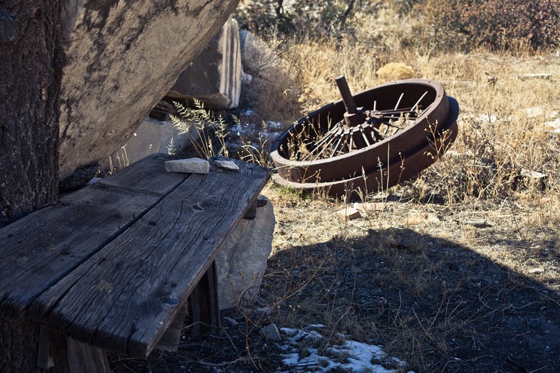 An old wheel beside an old table.