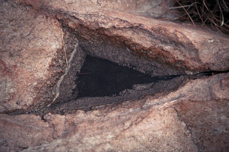 A triangle wedge in rock, filled with water.