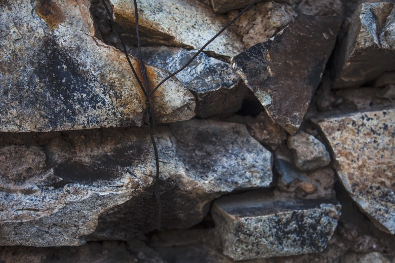 Wire through rocks, used to hold the roof on an abandoned cabin in the Dos Cabezas Wilderness.