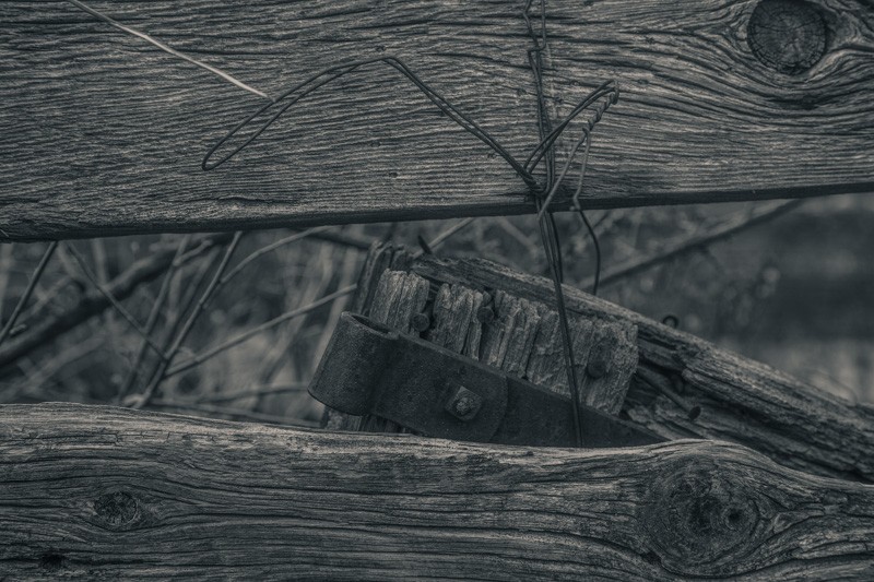 Old wooden fencing bound together by wire.